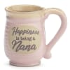Pink ceramic mug with beige rim and oval plaque reading “Happiness is being a Nana.”