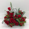 Red rose arrangement with an angel figurine in the center