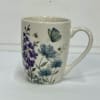 White ceramic mug with purple and blue floral and butterfly print