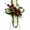 Standing floral cross with red roses and white chrysanthemums on an easel