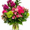 Pink and magenta flowers arranged in a clear glass vase