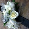 White rose corsage with silver ribbon and pearl accents on a black band