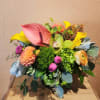 Colorful mixed floral arrangement with calla lilies, anthurium, and dahlias in a vase