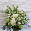 White and green floral arrangement in a clear glass vase