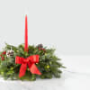 Holiday centerpiece with a red taper candle and evergreen wreath