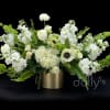 White floral arrangement in a gold vase with green accents