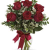 Bouquet of red roses with baby's breath in a glass vase tied with a red ribbon