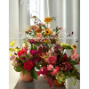 Two colorful mixed flower arrangements in vases with overlaid text.