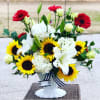 Bouquet of sunflowers, white lilies, and red gerbera daisies in a white vase