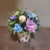 Mixed artificial flowers in a patterned ceramic pot