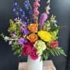 Colorful mixed bouquet in a white vase with roses and tall blooms
