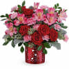 Red roses and pink alstroemeria in a red heart-patterned vase