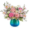 Pink roses and mixed blooms in a blue glass vase