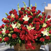 Basket arrangement of red roses and white lilies with a red ribbon