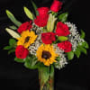 Bouquet of red roses and sunflowers in a clear glass vase