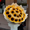 Bouquet of sunflowers and white roses wrapped in white paper