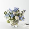 Blue and white flower arrangement in a clear glass vase