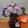 Pink roses and lavender daisies in a square glass vase