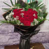 Bouquet of red roses with white baby's breath in black wrap