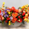 Colorful bouquet of mixed flowers in a white bowl vase