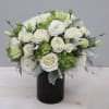 Compact white and green rose arrangement in a black cylinder vase
