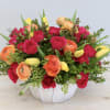 This joyful arrangement is made with bright pink spray roses, orange ranunculus