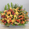 Large orange and yellow floral arrangement in a rectangular container