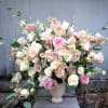 Large pastel bouquet of roses and lisianthus in a white vase