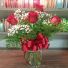 6 Red Roses arranged in a clear vase with greenery and Babies