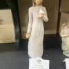 A small angel figurine in a white dress holding a dove