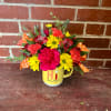 Bouquet of pink, yellow, and coral flowers in a yellow mug
