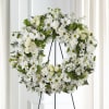 White floral wreath on a black stand