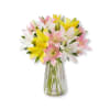 Bouquet of pink, white, and yellow lilies in a clear glass vase