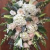 Large white and blush floral standing spray with lilies, roses, and hydrangeas