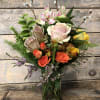 Mixed bouquet of roses, lilies, and pussy willow in a glass vase