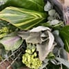 Bouquet of assorted green foliage with a few pale green blooms