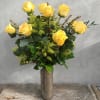 Yellow roses arranged in a tall textured vase