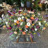 Large colorful floral spray on a wooden stand