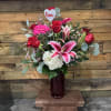 Bouquet of red roses, pink lilies, and white hydrangea in a vase