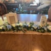 Low floral garland with white and blue blooms on a table