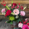 Bouquet of red and pink roses with gerbera daisies in a vase