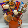 Candy bouquet in an orange mug with pumpkin decorations and a fall tag