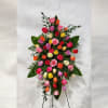 Tall standing spray of multicolored roses on an easel