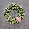 White floral wreath on a stand with a baseball at the lower right