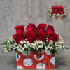 Red roses arranged in a decorated box with white baby's breath
