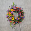 Large colorful floral wreath on a black stand