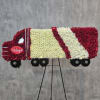 A handcrafted semi truck tribute covered in white chrysanthemums with red accents