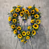 Heart-shaped sunflower wreath on a stand with blue flowers