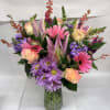 Soft pink gerbera daisies and pink roses take center stage in this