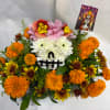 Floral arrangement shaped like a skull with a decorative card on top